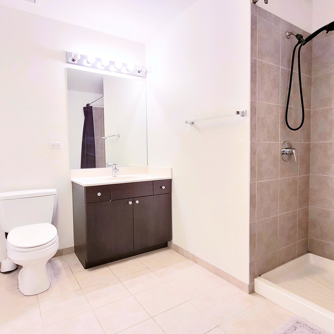 Undisclosed Address Chicago, IL 60607 - Photo 14 of 26 a bathroom with a granite countertop sink toilet and shower