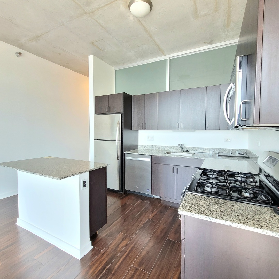 Undisclosed Address Chicago, IL 60607 - Photo 6 of 26 a kitchen with a refrigerator and a stove top oven