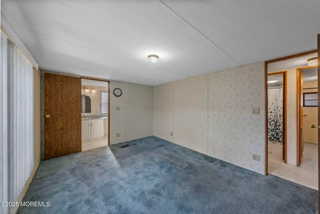 an empty room with closet and windows