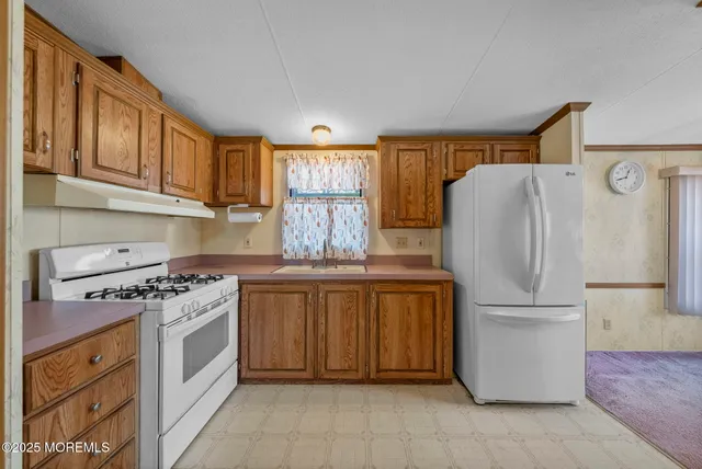 a kitchen with stainless steel appliances granite countertop a refrigerator sink and stove