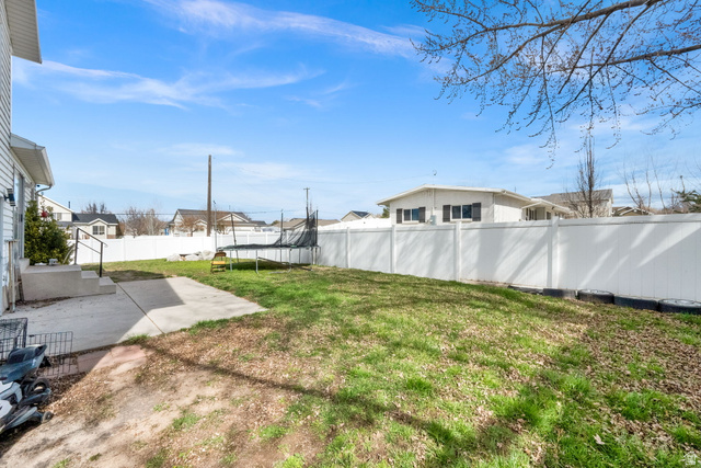 1284 North 900 West Clinton, UT 84015 - Photo 6 of 22 Fenced backyard with a trampoline, a patio area, and a residential view