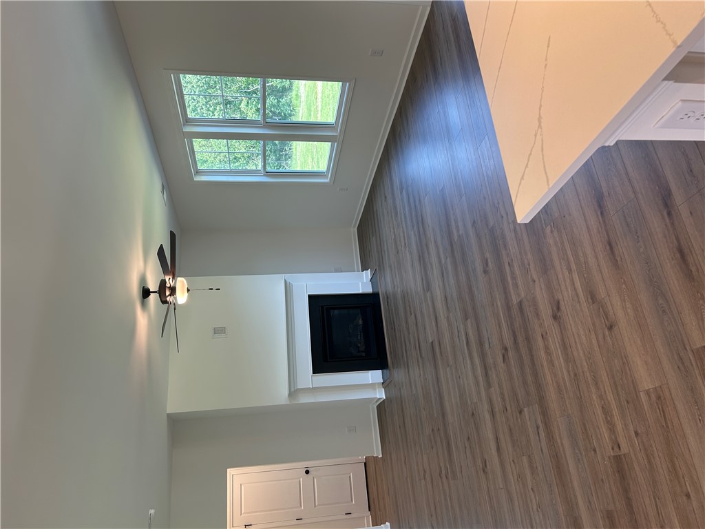 202 Bellflower Lane Pendleton, SC 29670 - Photo 10 of 27 A living space offers a fireplace, wood floors, and abundant natural light from elevated windows.