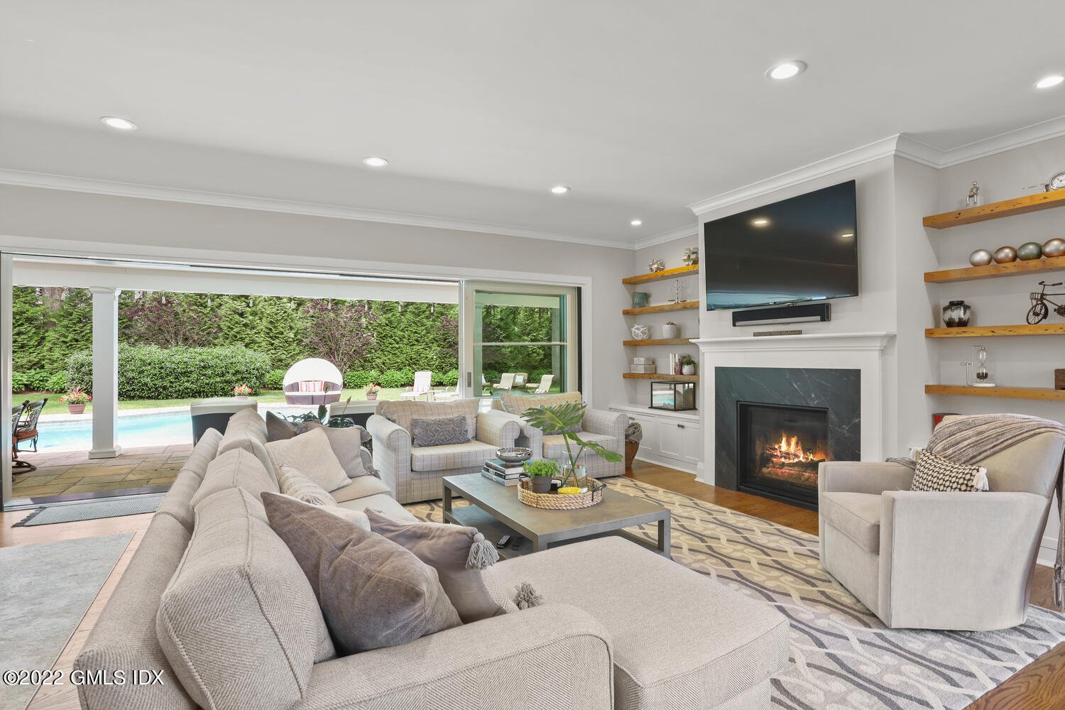 2 Loch Lane Greenwich, CT 06830 - Photo 18 of 64 a living room with couches a fireplace and a flat screen tv