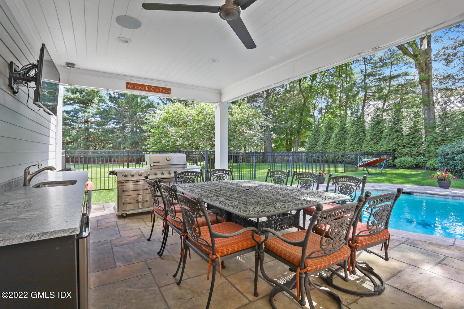 2 Loch Lane Greenwich, CT 06830 - Photo 52 of 64 a view of a patio with a table chairs and a floor to ceiling window