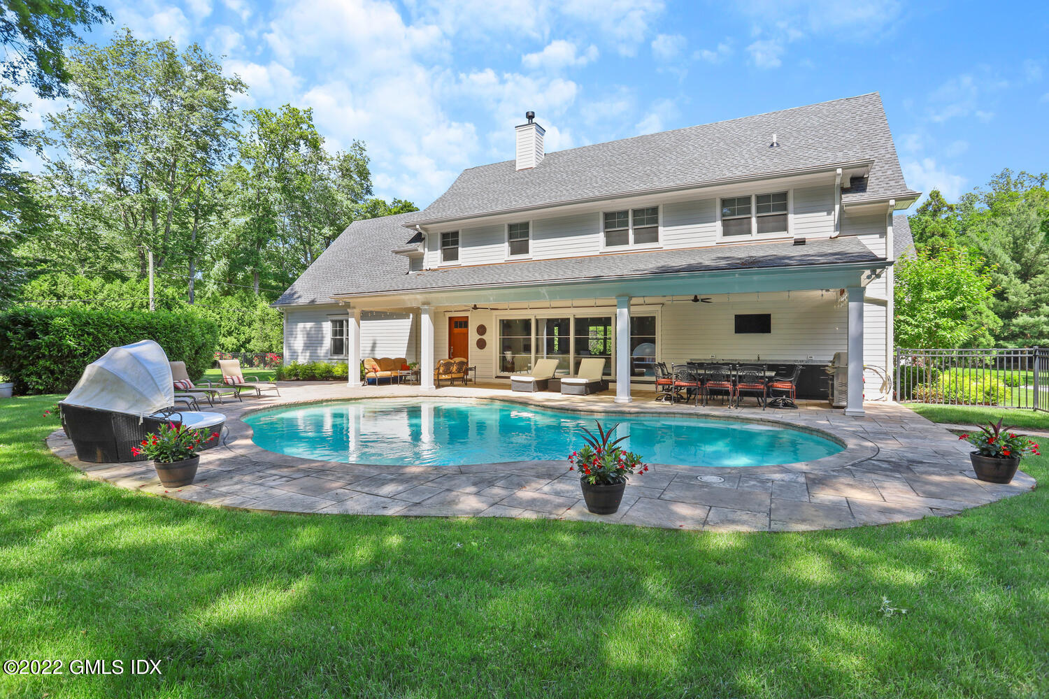 2 Loch Lane Greenwich, CT 06830 - Photo 55 of 64 a front view of a house with a yard table and chairs