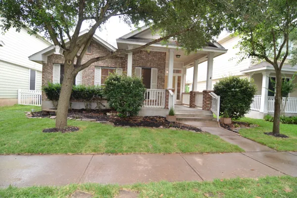 a front view of a house with a garden and plants