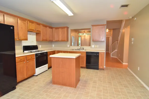 a kitchen with stainless steel appliances granite countertop a stove a sink dishwasher a refrigerator and cabinets with wooden floor