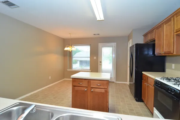 a kitchen with stainless steel appliances granite countertop a stove a sink and a refrigerator