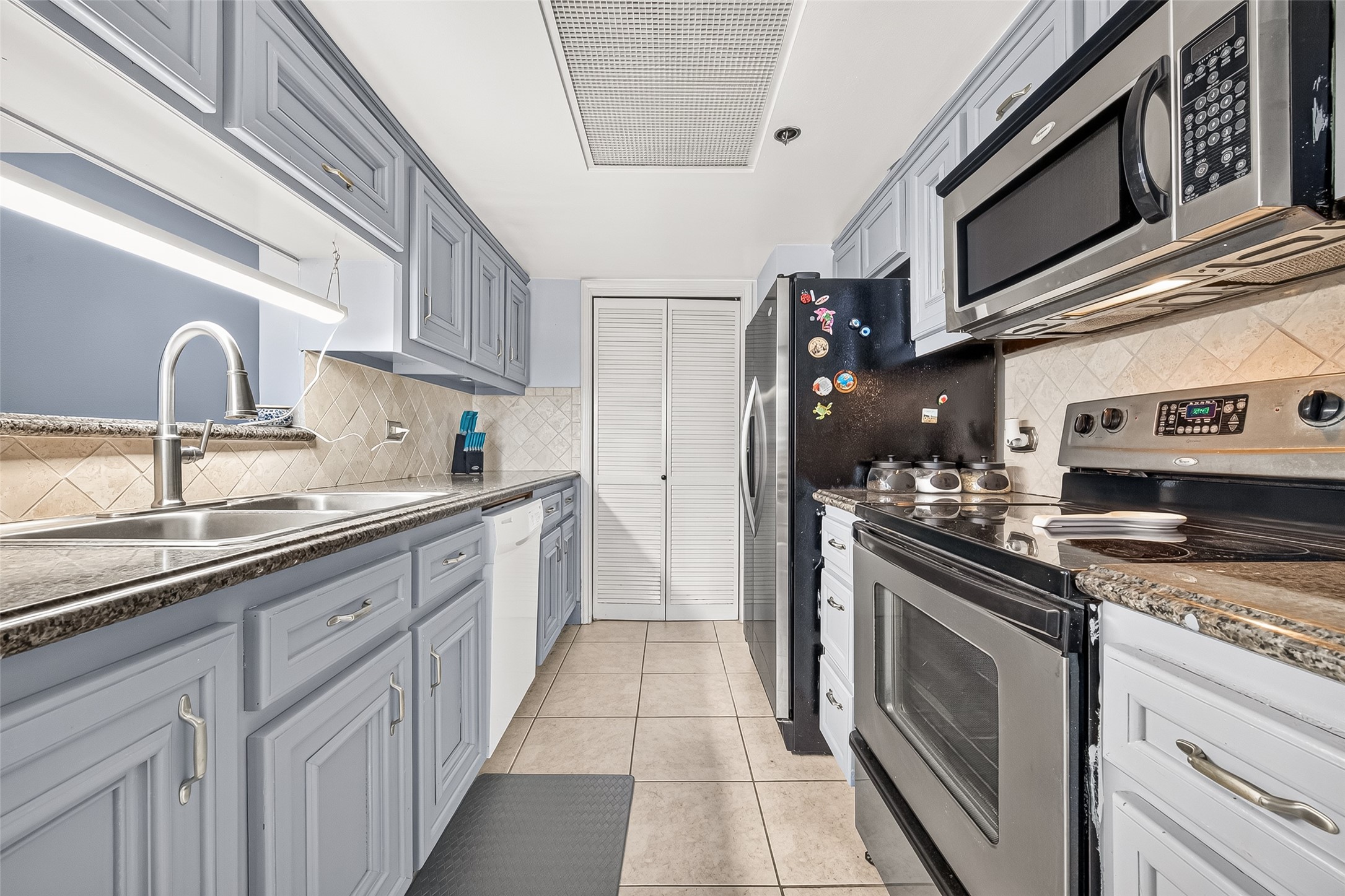 3525 Sage Road, Unit 1116 Houston, TX 77056 - Photo 14 of 25 Galley-style kitchen featuring granite countertops and generous storage.