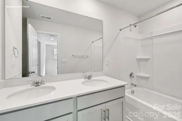 a bathroom with a granite countertop sink mirror and a bathtub
