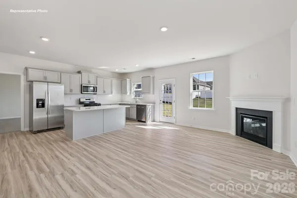 a view of kitchen with granite countertop cabinets and refrigerator