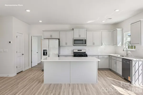 a kitchen with cabinets wooden floor and stainless steel appliances