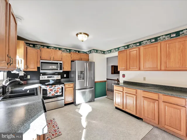a kitchen with stainless steel appliances a stove sink and cabinets