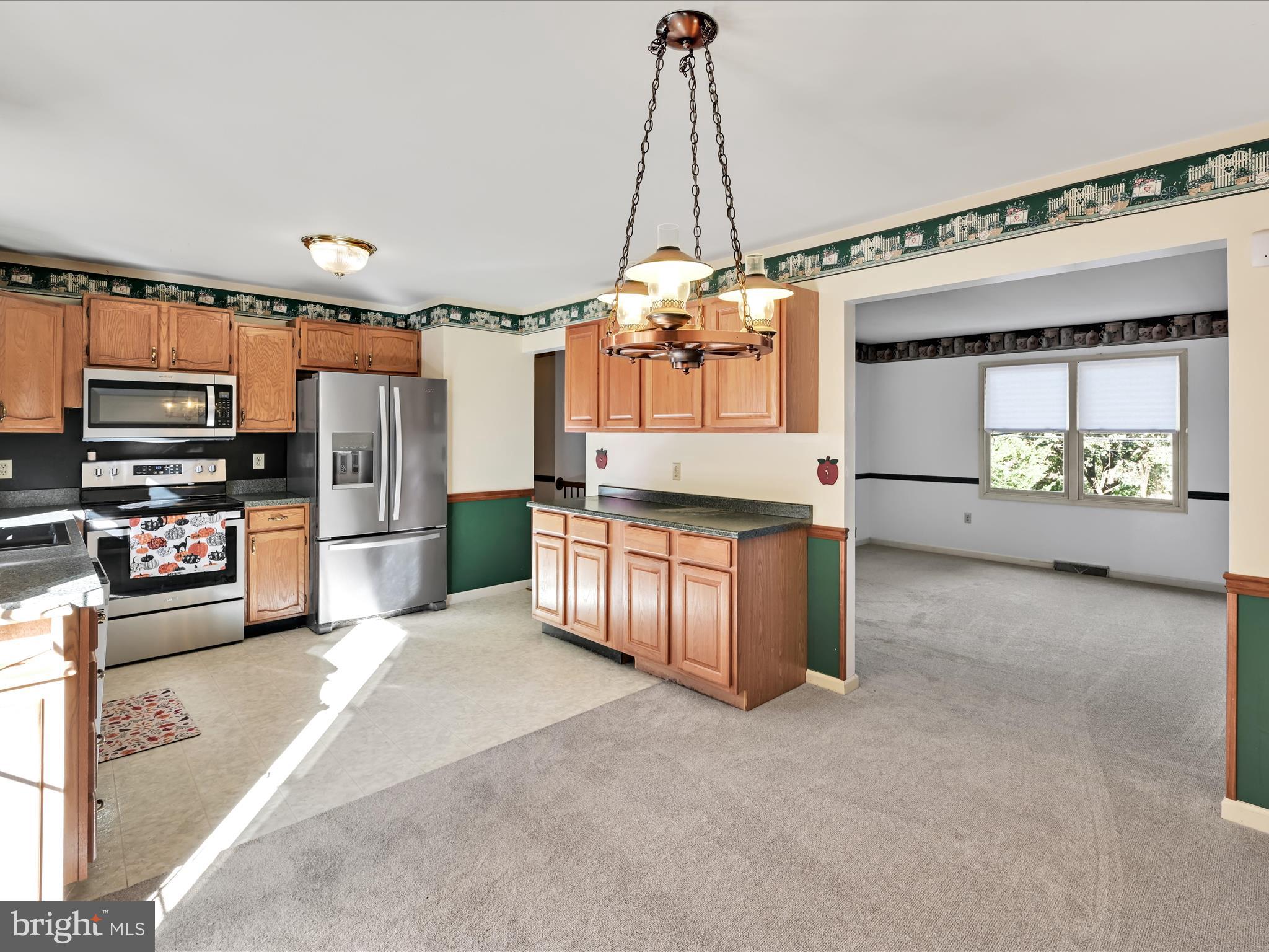 2032 Main Street Lititz, PA 17543 - Photo 8 of 32 a large kitchen with stainless steel appliances kitchen island granite countertop a refrigerator oven a sink and dishwasher