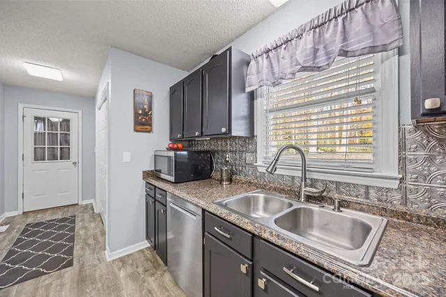 a kitchen with granite countertop a sink and a stove top oven