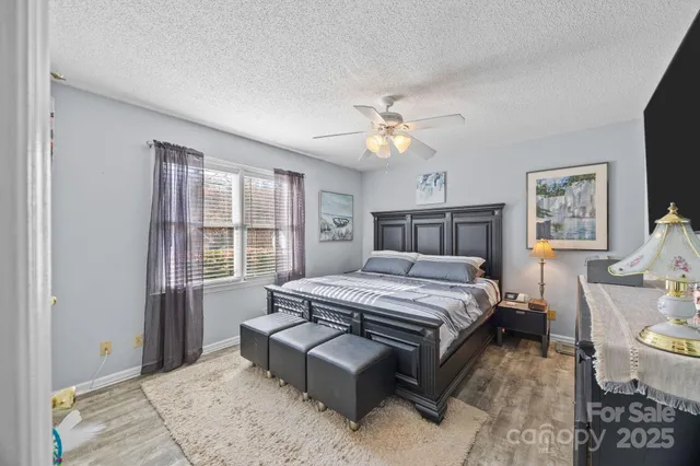 a bedroom with a bed wooden floor and window