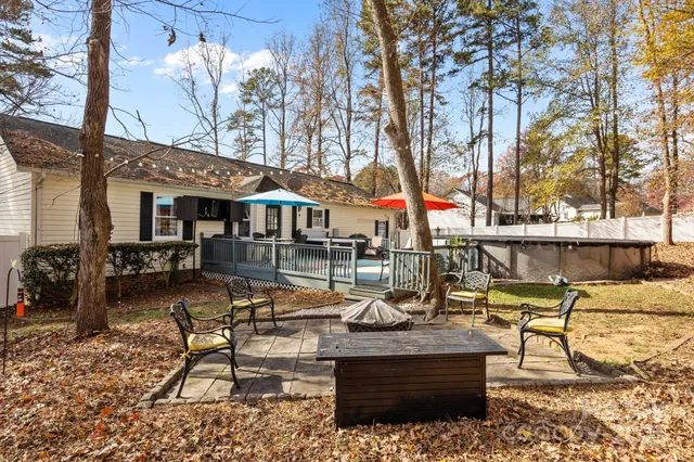 a view of a patio with table and chairs potted plants and large tree