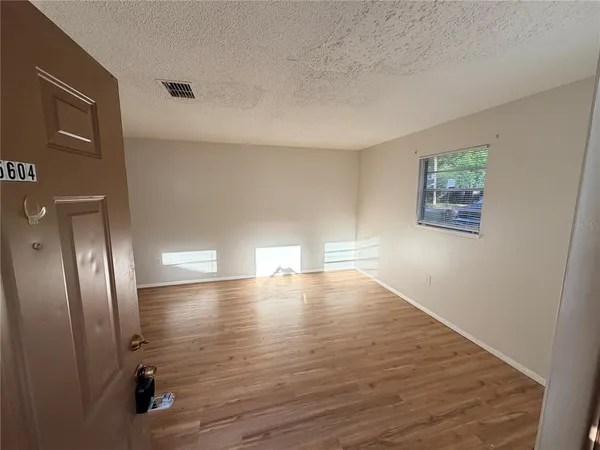a view of empty room with wooden floor
