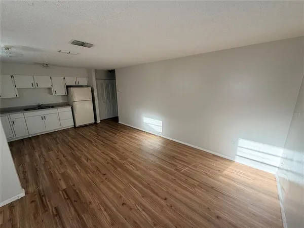 a view of a kitchen with wooden floor and a sink