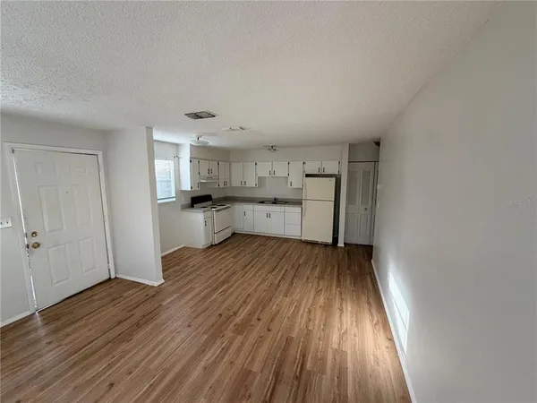 a view of a kitchen with wooden floor and electronic appliances