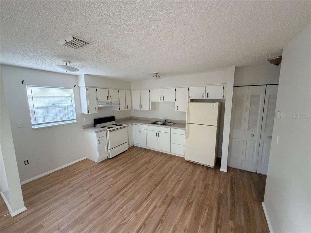 5604 Montana Avenue New Port Richey, FL 34652 - Photo 5 of 10 a kitchen with white cabinets and wooden floor