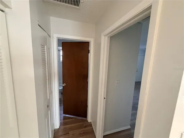 a view of a hallway with wooden floor