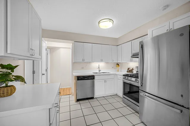 a kitchen with stainless steel appliances granite countertop a refrigerator sink and stove