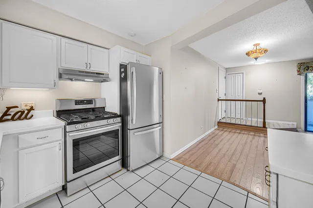 a kitchen with white cabinets and stainless steel appliances