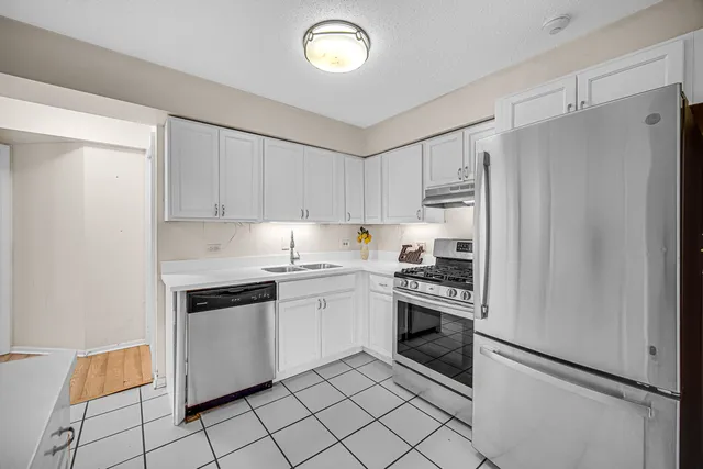a kitchen with cabinets stainless steel appliances and a counter space