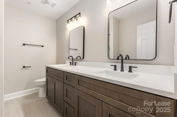 a bathroom with double vanity sinks and a mirror