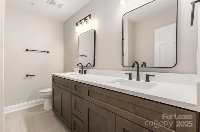 a bathroom with double vanity sinks and a mirror