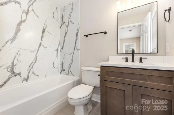 a bathroom with a sink toilet vanity and bathtub