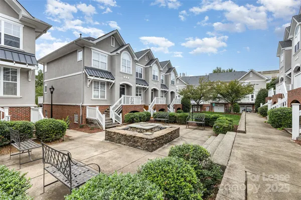 a front view of a house with garden and trees