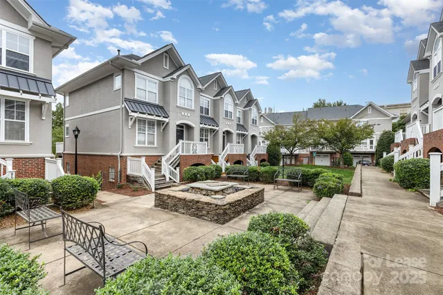 a front view of a house with garden and trees