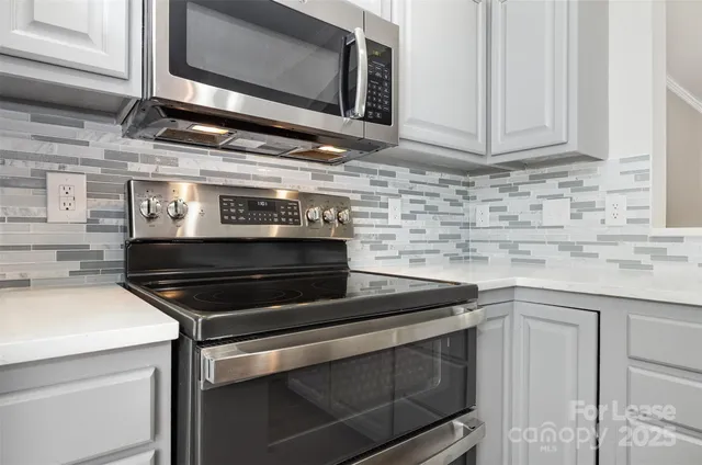 a kitchen with granite countertop a stove microwave and sink