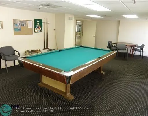 a room with pool table and windows