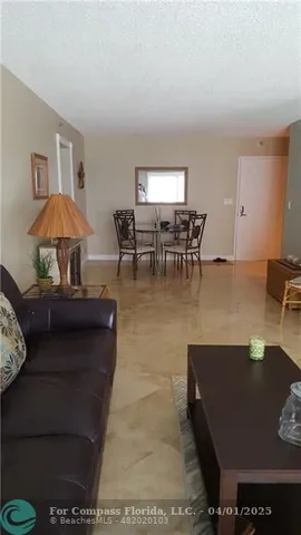 a living room with furniture and a dining table with chairs