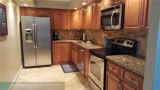 a kitchen with stainless steel appliances granite countertop a refrigerator stove and microwave