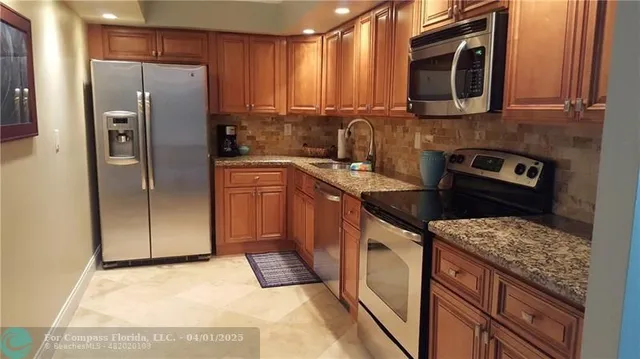 a kitchen with stainless steel appliances granite countertop a refrigerator stove and microwave