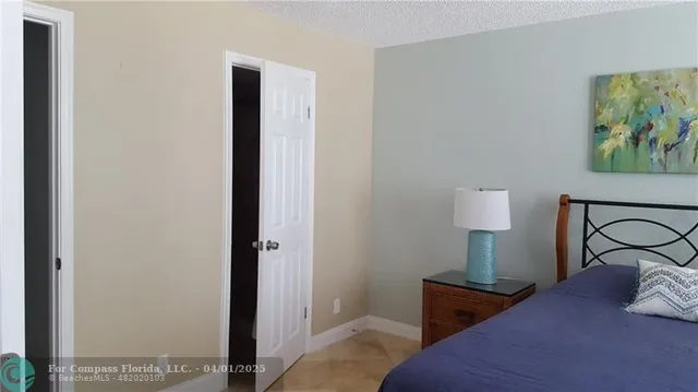 a bedroom with a bed and a lamp on dresser