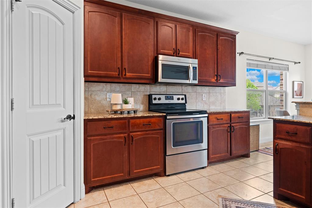 2322 Trace Ridge Drive Weatherford, TX 76087 - Photo 12 of 30 Kitchen with stainless steel appliances, light stone counters, light tile patterned flooring, and decorative backsplash
