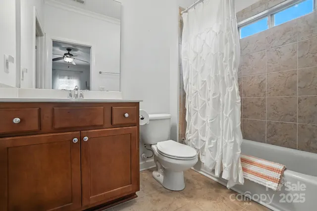 a bathroom with a granite countertop sink a toilet and shower