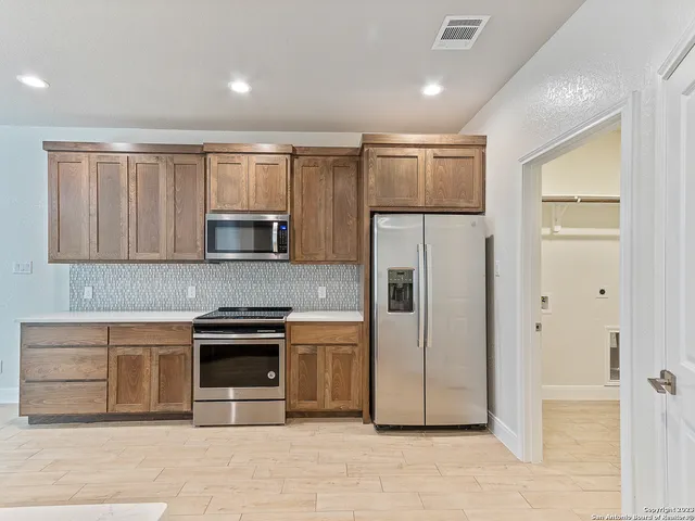 a kitchen with stainless steel appliances granite countertop a refrigerator and a stove top oven