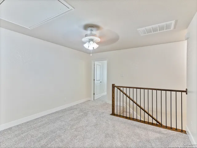 an empty room with chandelier fan