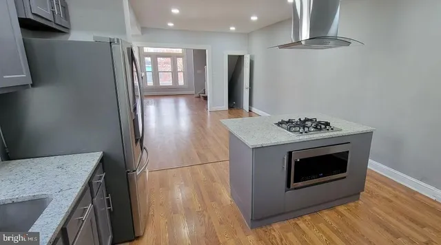a kitchen with granite countertop a sink stove and refrigerator