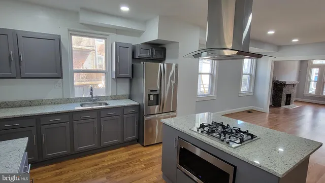 a kitchen with stainless steel appliances granite countertop a sink stove and refrigerator