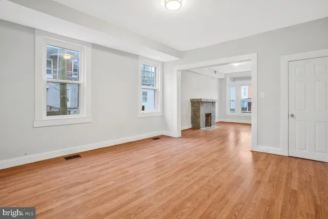 a view of empty room with wooden floor and fireplace