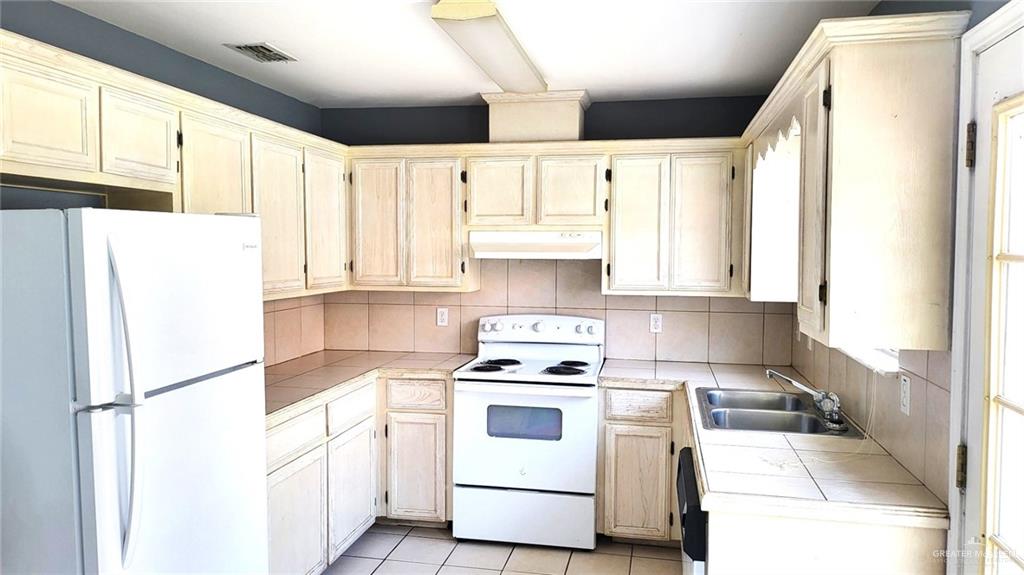 2405 Redbud Avenue McAllen, TX 78504 - Photo 3 of 5 a kitchen with white cabinets and white appliances