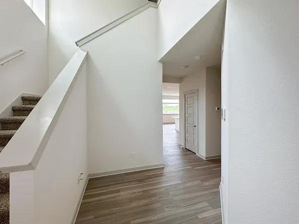 a view of a hallway with wooden floor and staircase
