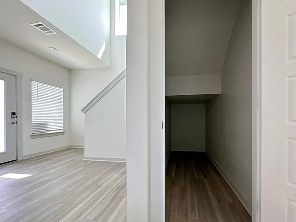a view of a hallway with wooden floor and staircase